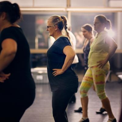 A group of women dressed in workout clothes with their hands on their hips