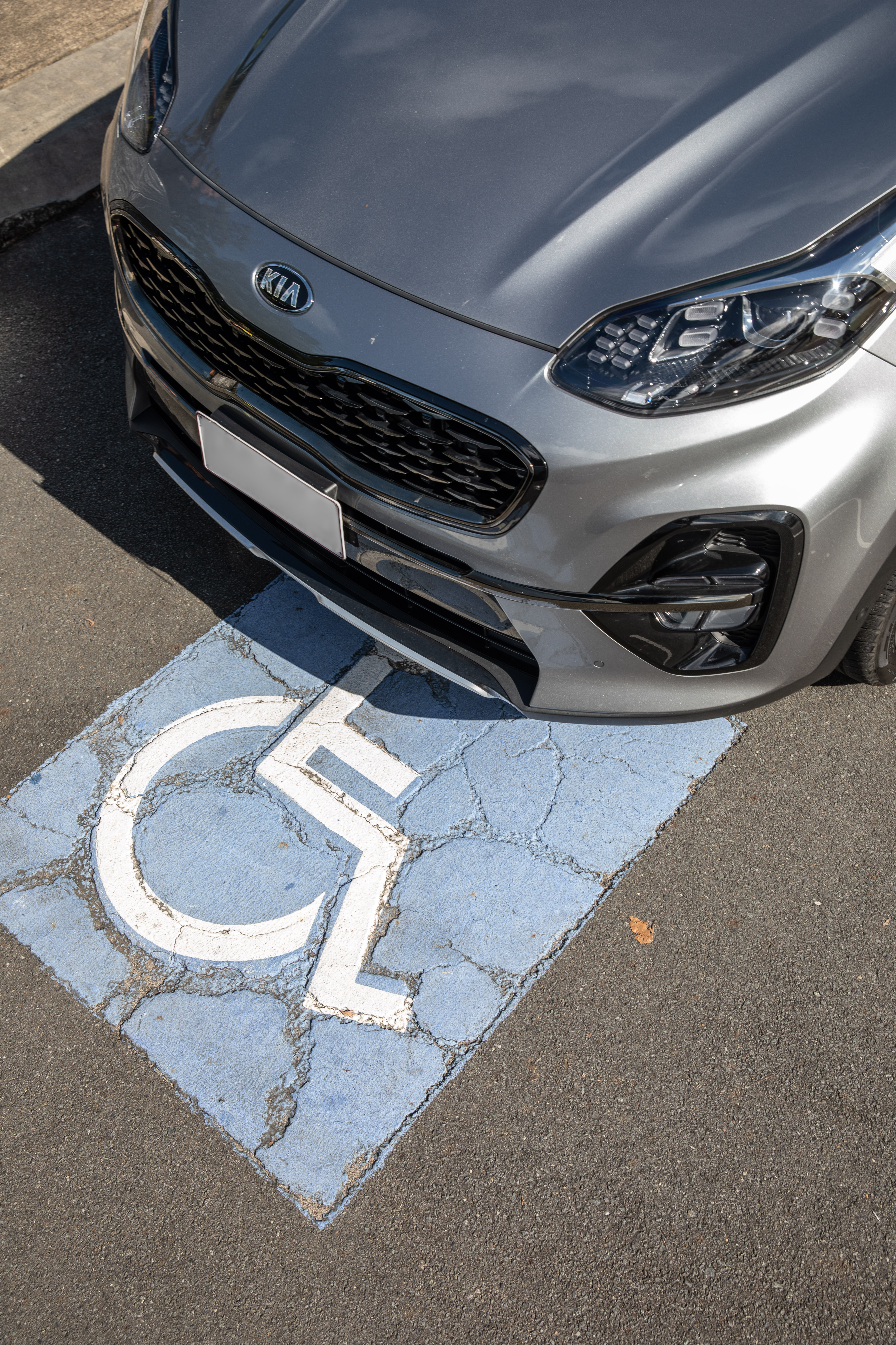 Car parked in a disability park, the blue icon visible under the front bonnet of the car.