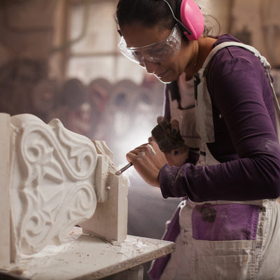 Woman carves intricate design into piece of concrete