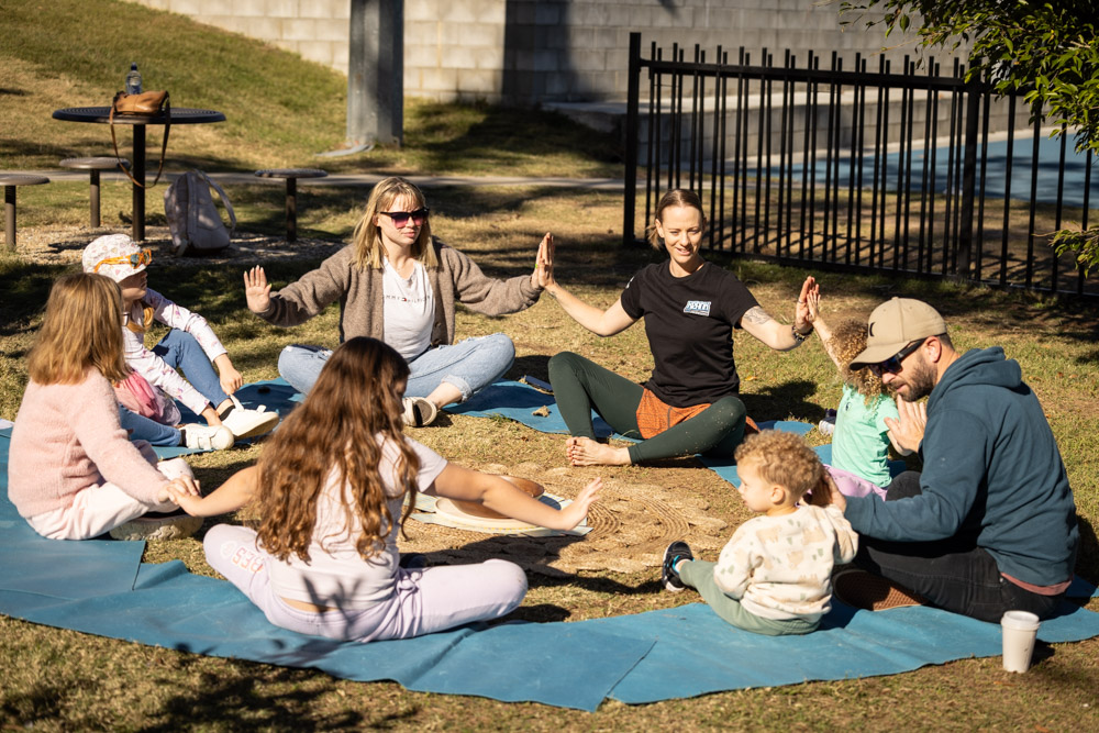 Group of children sit in a circle and perform yoga moves