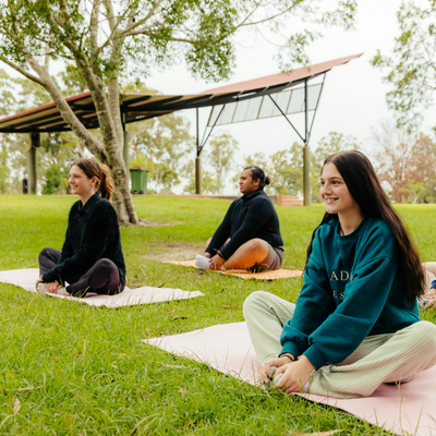 Girl smiles while sitting in a yoga pose