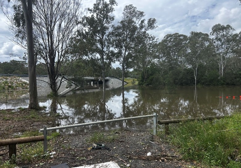 A view of the former low level road crossing showing the creek flooded and the bridge above the water level
