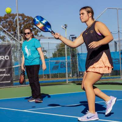 Two women playing pickleball