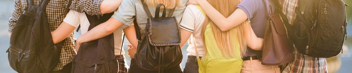 Picture of friends wearing backpacks with their arms around each other