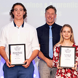 Two people hold awards and stand next to mayor