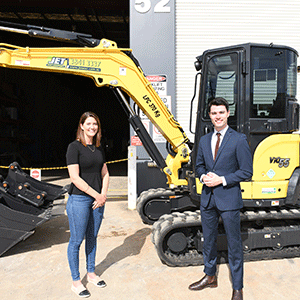 Image of man, woman and earthmoving equipment.