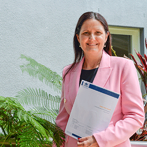 woman holds document in front of wall