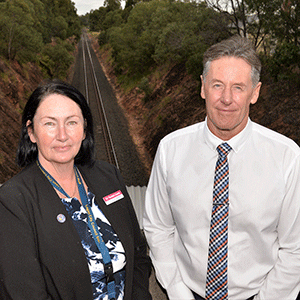 Woman and man stand at railway overpass