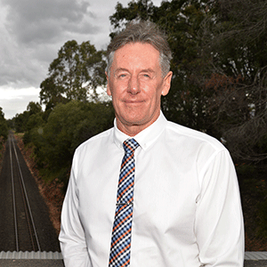 Man stands on bridge over railway line